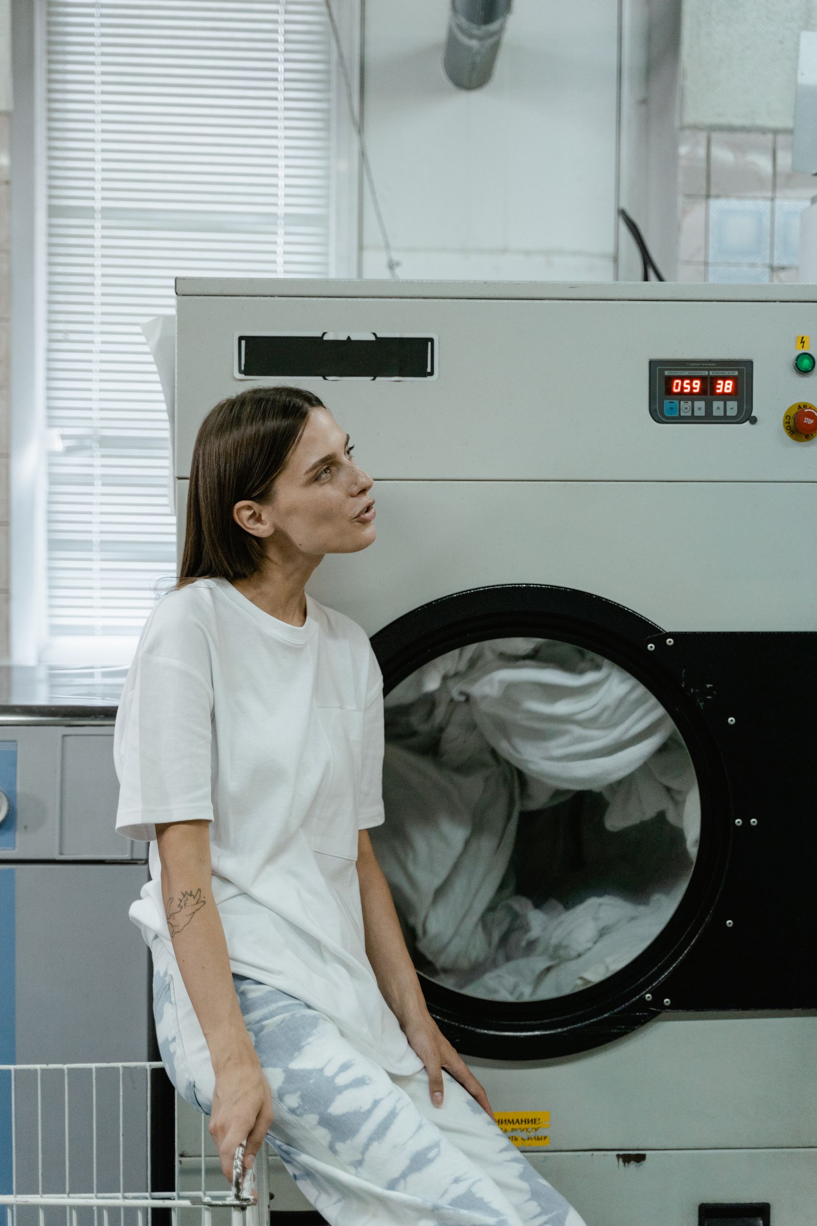 A woman beside washing machines in a laundromat